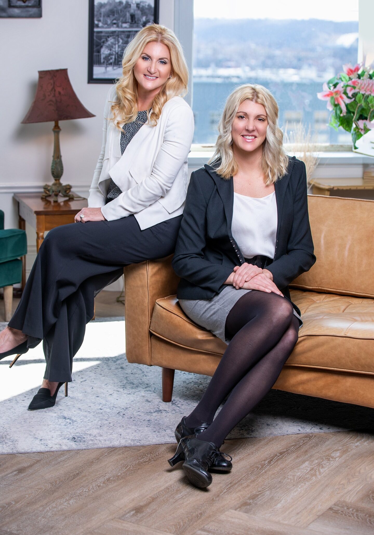 Coleen and Bonnie owners of 3B Realty Group in Cincinnati sitting in a chair